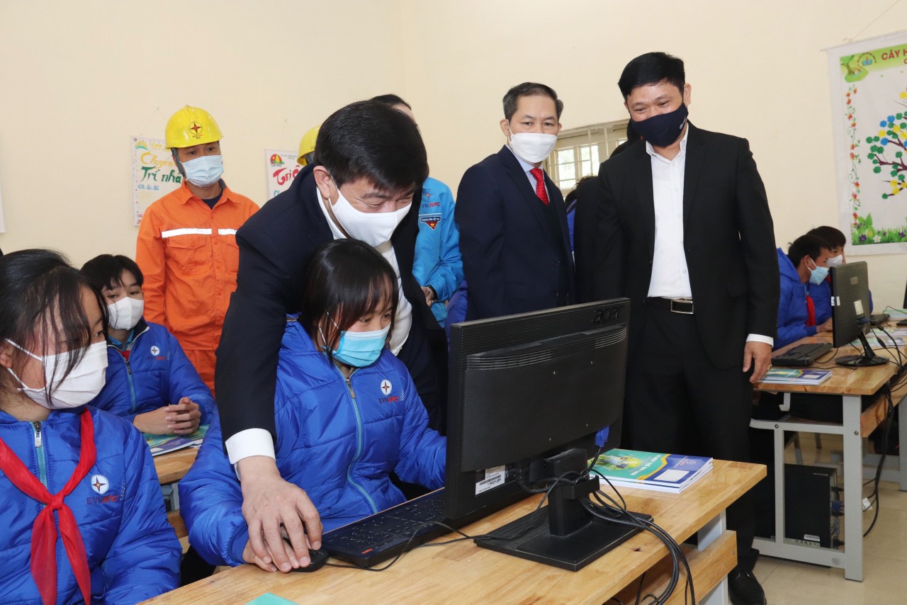 Ông Lê Văn Trang - Phó Tổng giám đốc EVNNPC hướng dẫn các em học sinh sử dụng máy tính tại Phòng máy xanh