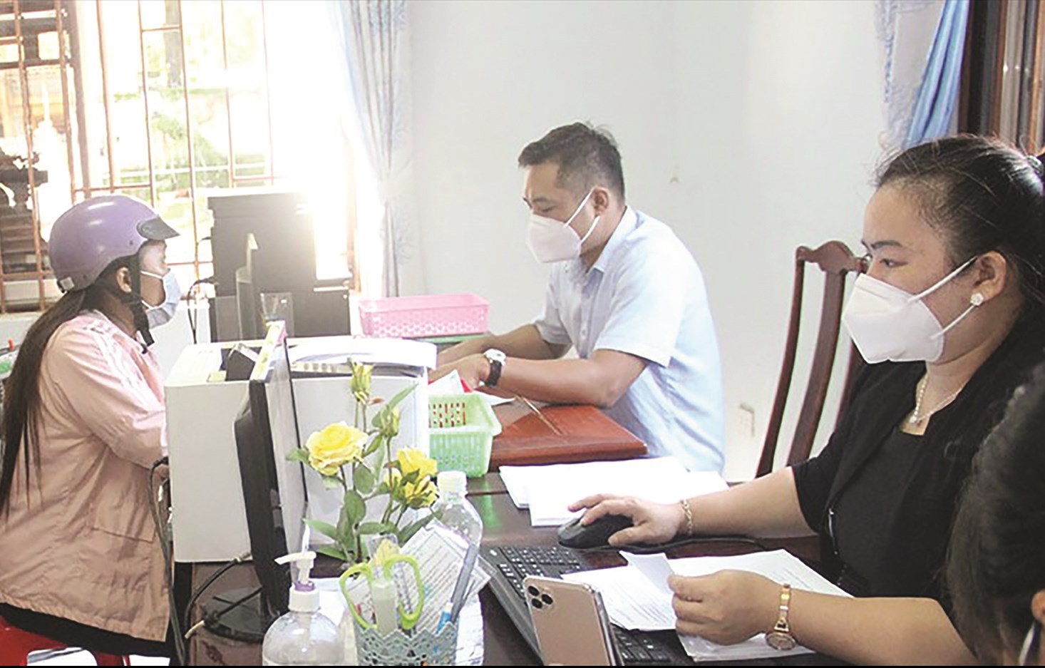 Cán bộ Bảo hiểm xã hội huyện Bù Đốp làm thủ tục cấp thẻ bảo hiểm y tế cho người dân
