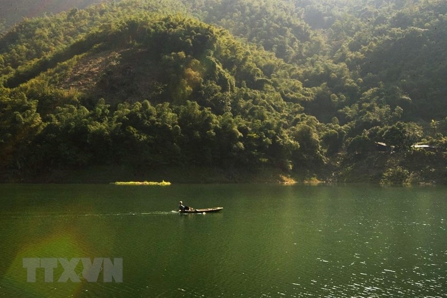 Một người đánh lưới thong thả chèo thuyền trong một buổi sáng bình yên trên hồ Hòa Bình. (Ảnh: Trọng Đạt/TTXVN)