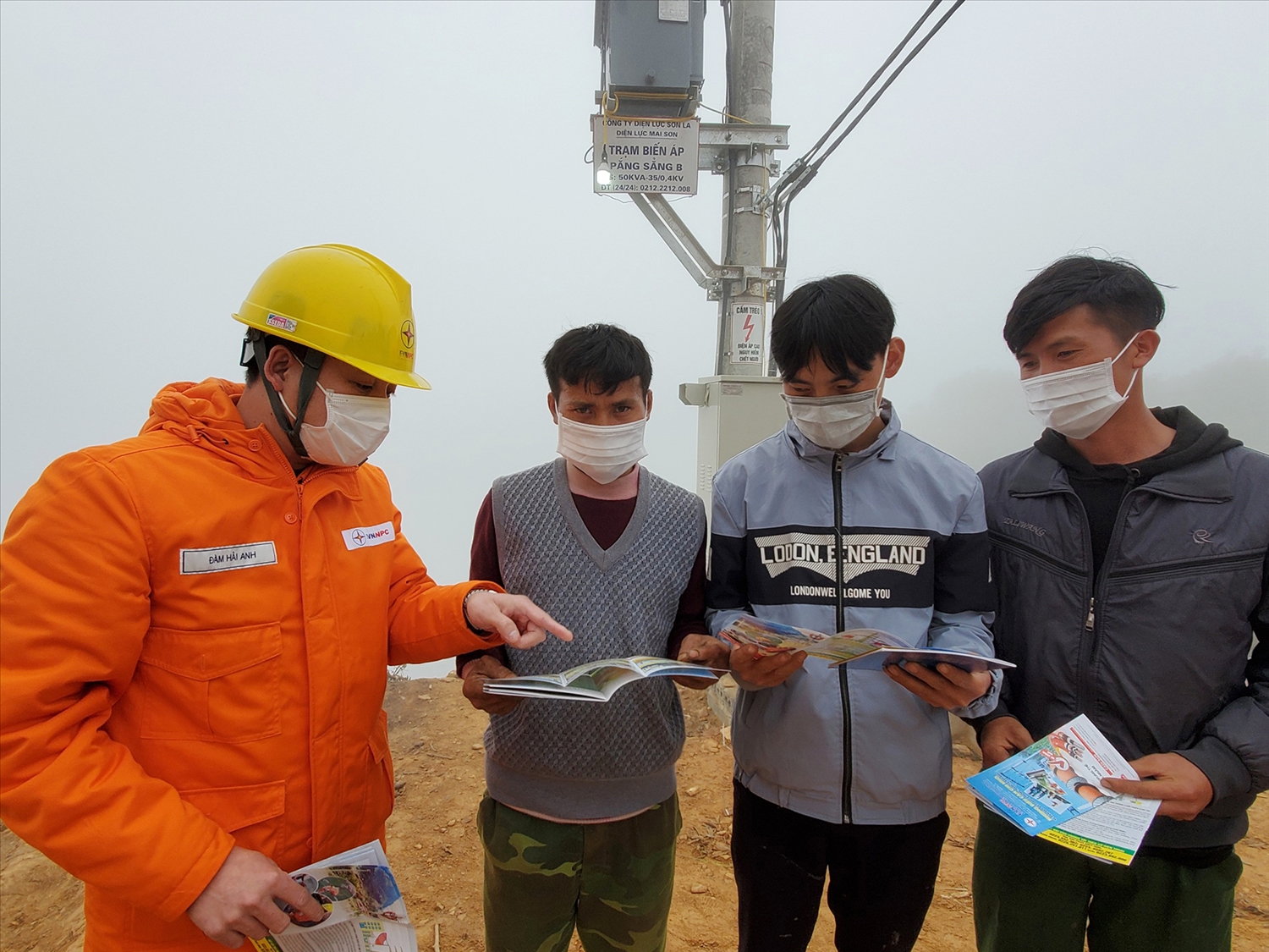 Cán bộ Điện lực Sơn La hướng dẫn người dân xã Chiềng Kheo cách sử dụng điện tiết kiệm