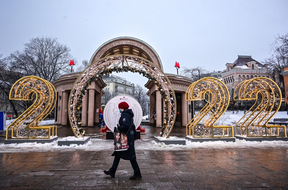 Một phụ nữ đi bộ đi qua khu trang trí năm mới 2022 trước ga tàu điện ngầm Kropotkinskaya ở Moskva, Nga ngày 29/12.