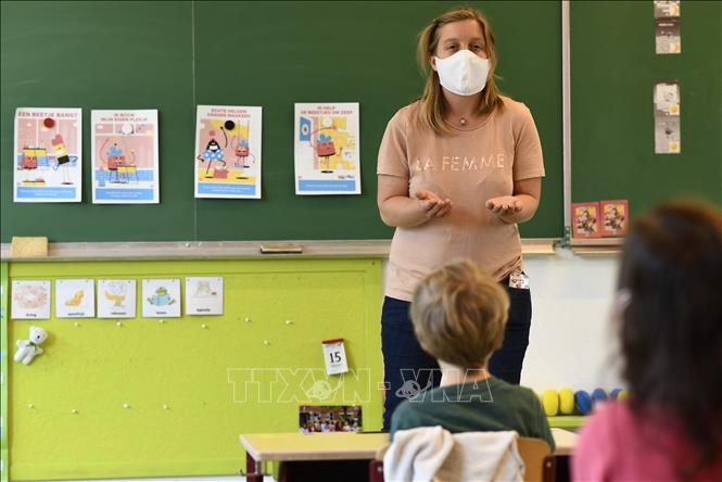 Giáo viên và học sinh đeo khẩu trang phòng lây nhiễm COVID-19 tại một lớp học ở Brussels, Bỉ. Ảnh: AFP/TTXVN