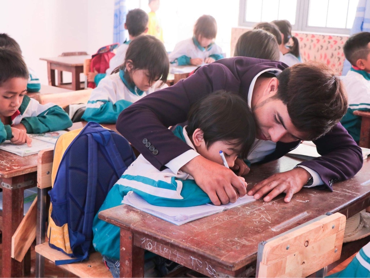 Thầy giáo Tưih - Trường Tiểu học số 1 Ia Băng, huyện Đak Đoa ân cần hướng dẫn học sinh viết chữ