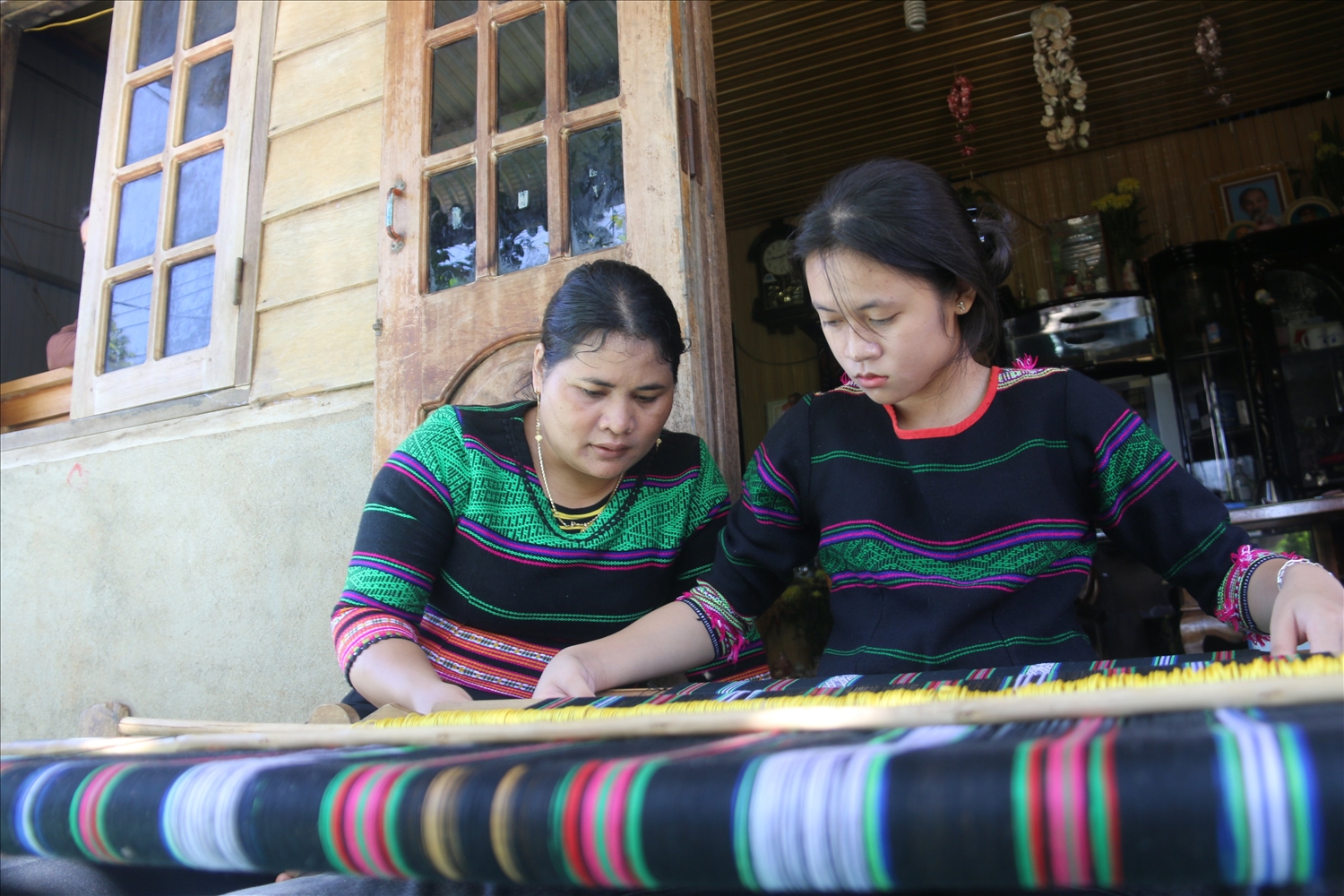 Nghệ nhân H’Bình truyền dạy nghề dệt thổ cẩm cho con gái Trần H’Nhàn