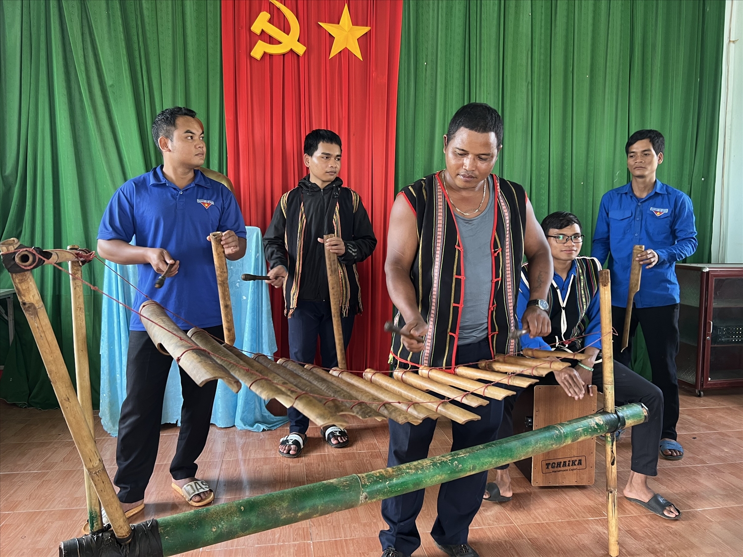 Anh Kpuih Dyui - Chủ nhiệm Câu lạc bộ đàn T’rưng làng Ấp cùng học viên hoà tấu nhạc T’rưng tại lớp học