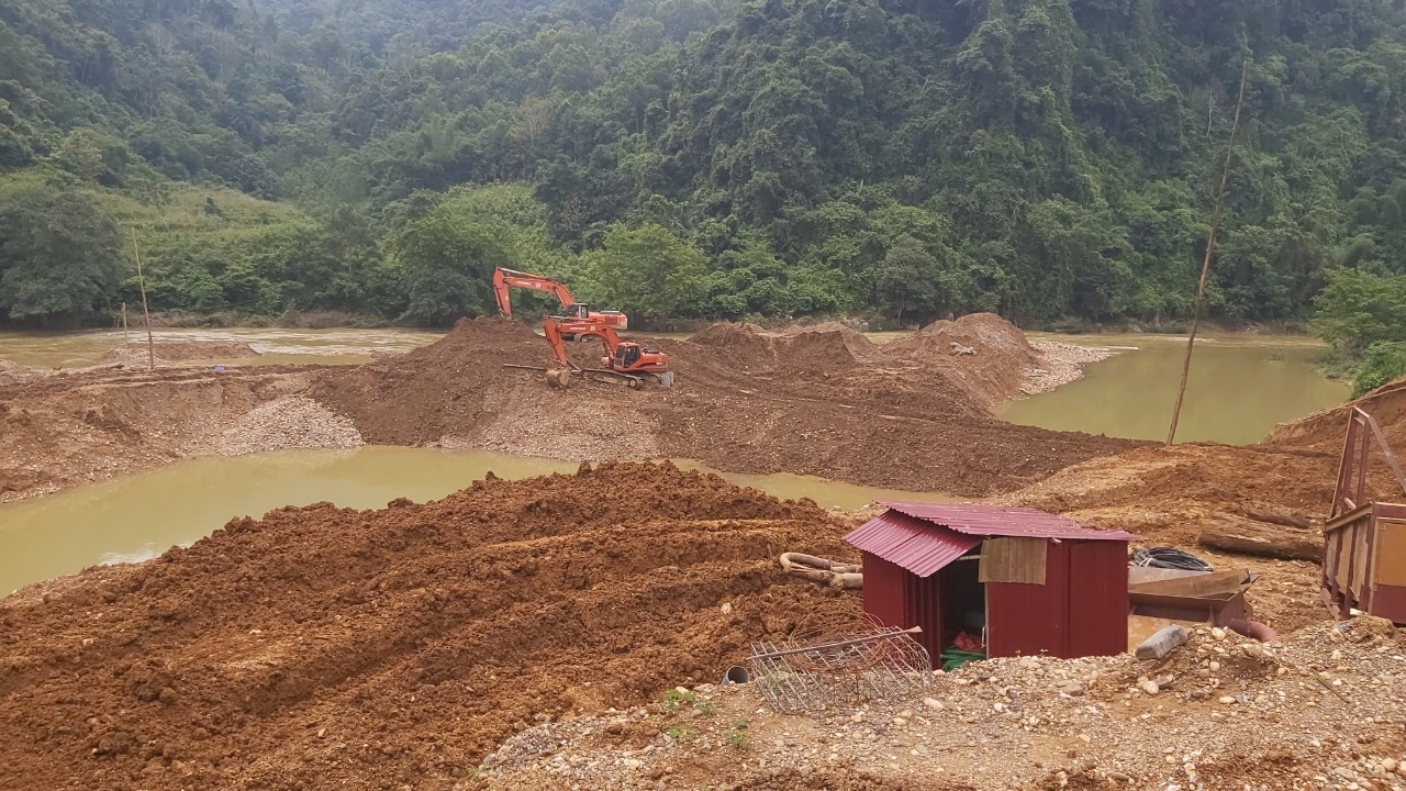 Khu vực thôn Hát Lài 02 chiếc máy xúc đang “ngăn sông, đắp đập” đào xới nham nhở dòng sông để tìm kiếm khoáng sản. 