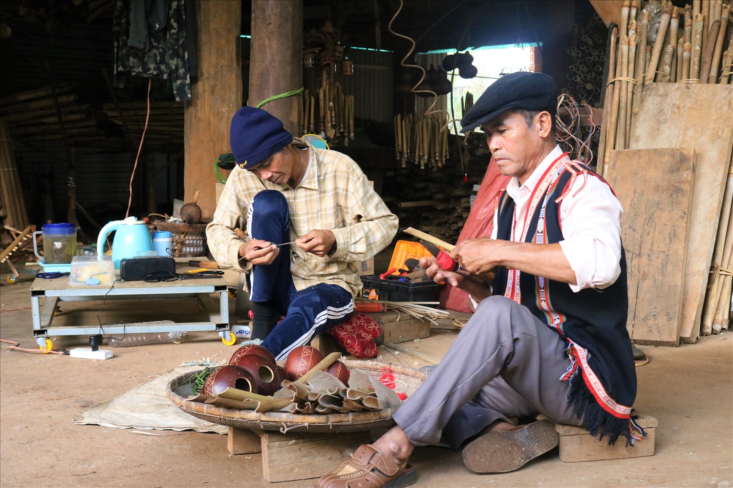 Ông Rơ Châm Tih, người Gia Rai (bên trái) huyện Ia Grai cùng người trong làng chế tạo nhạc cụ dân tộc
