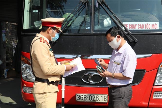 Tổ công tác của Trạm Cảnh sát giao thông Tam Điệp, Phòng Cảnh sát giao thông Công an tỉnh Ninh Bình kiểm tra một xe chở khách trên tuyến Quốc lộ 1A. Ảnh: Đức Phương - TTXVN