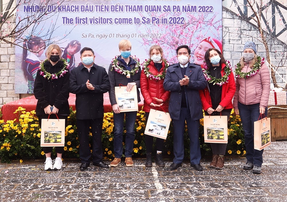 Lãnh đạo thị xã Sa Pa và Hiệp hội Du lịch Sa Pa trao quà cho những vị khách nước ngoài đầu tiên đến Sa Pa dịp năm mới 2022.