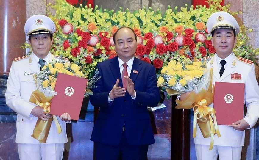 Chủ tịch nước Nguyễn Xuân Phúc trao Quyết định thăng cấp bậc hàm từ Trung tướng lên Thượng tướng đối với Thứ trưởng Bộ Công an Trần Quốc Tỏ và Lương Tam Quang. (Ảnh: Thống Nhất/TTXVN)