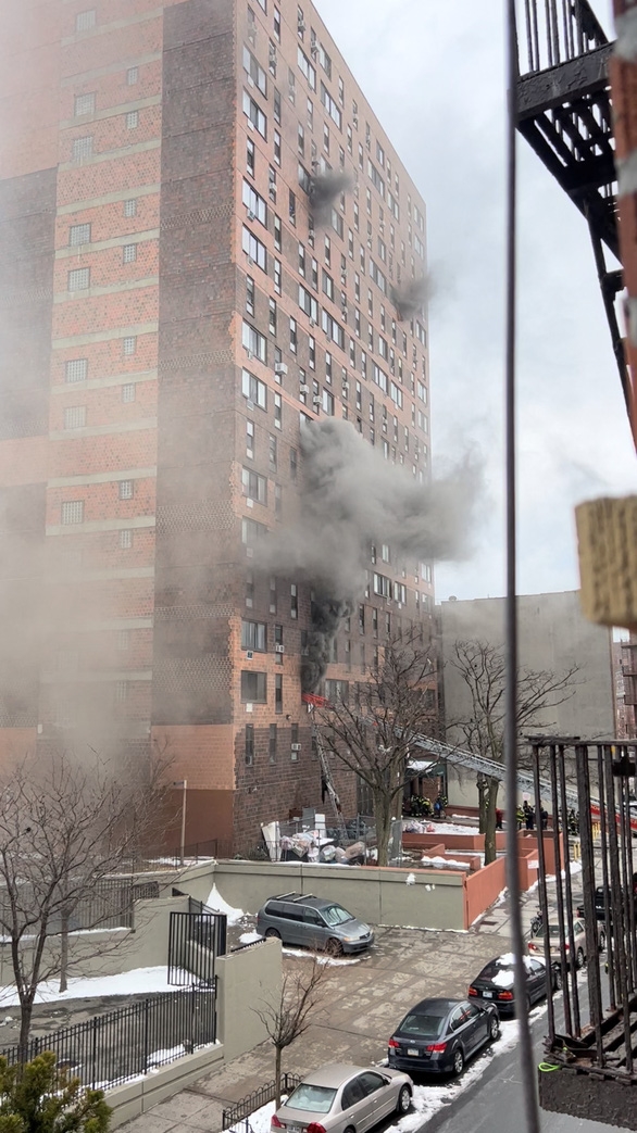 Khói bốc lên từ các cửa sổ trong vụ hỏa hoạn tại tòa chung cư ở quận Bronx, TP New York vào ngày 9-1 - Ảnh: REUTERS
