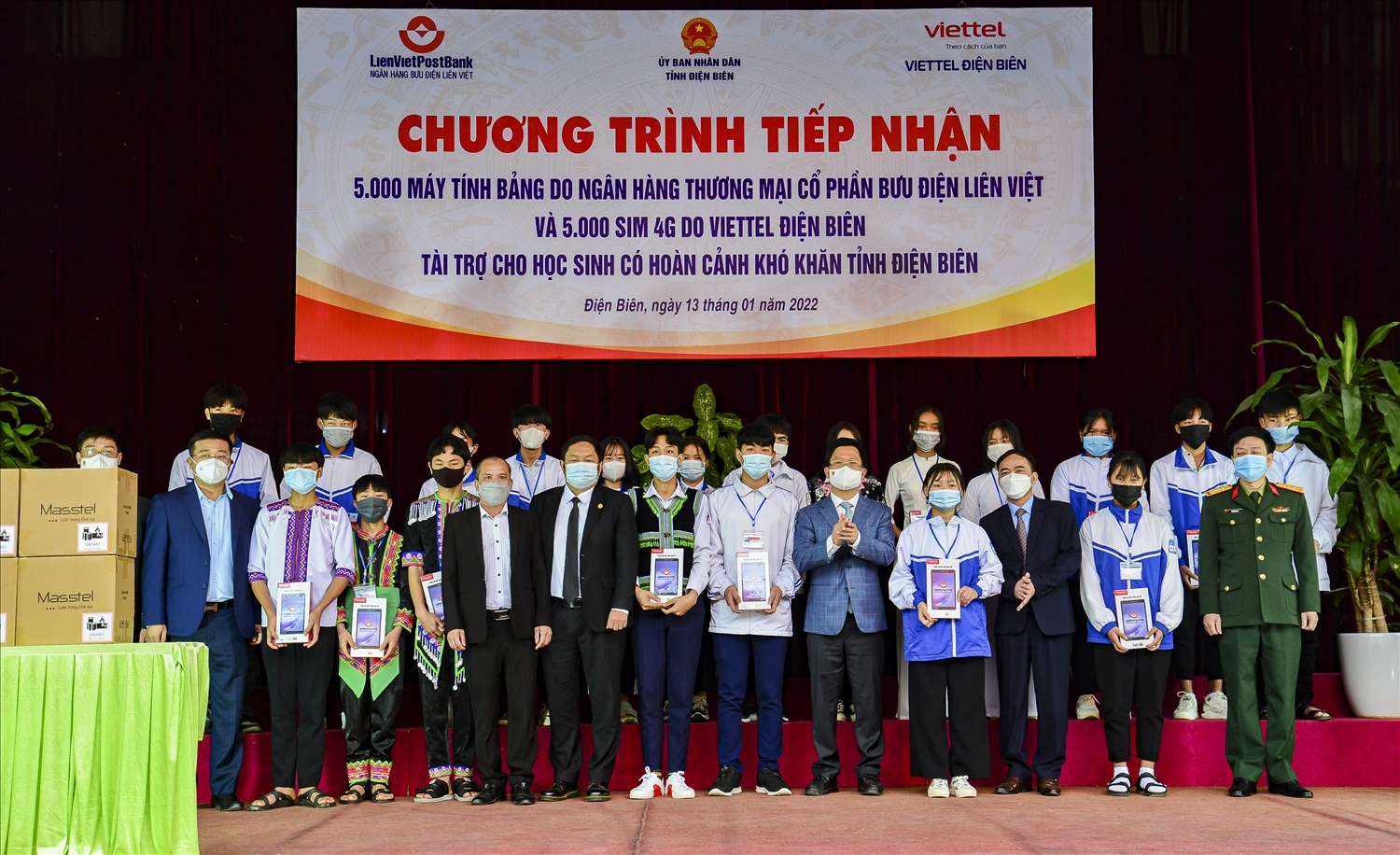 Ông Huỳnh Ngọc Huy, Chủ tịch Hội đồng quản trị Ngân hàng Thương mại cổ phần Bưu điện Liên Việt trao máy tính bảng cho đại diện 20 học sinh nghèo của tỉnh Điện Biên