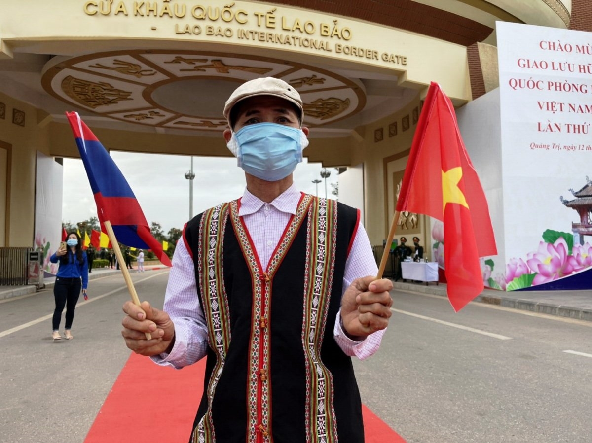 Ông Hồ Tiếp, người Vân Kiều, ở bản Ka Tăng, thị trấn Lao Bảo cầm trên tay 2 lá cờ Việt Nam và Lào chuẩn bị đón đoàn Lào trong chương trình Giao lưu hữu nghị Quốc phòng biên giới Việt Nam- Lào lần thứ nhất