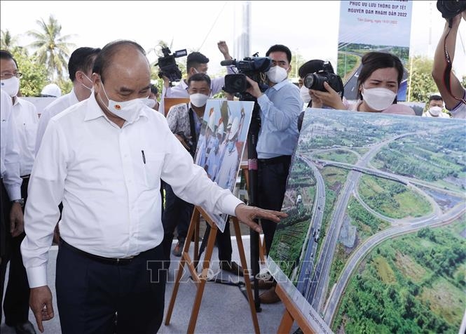 Chủ tịch nước Nguyễn Xuân Phúc xem trưng bày ảnh quá trình thi công Dự án tuyến đường cao tốc Trung Lương-Mỹ Thuận. Ảnh: Thống Nhất/TTXVN