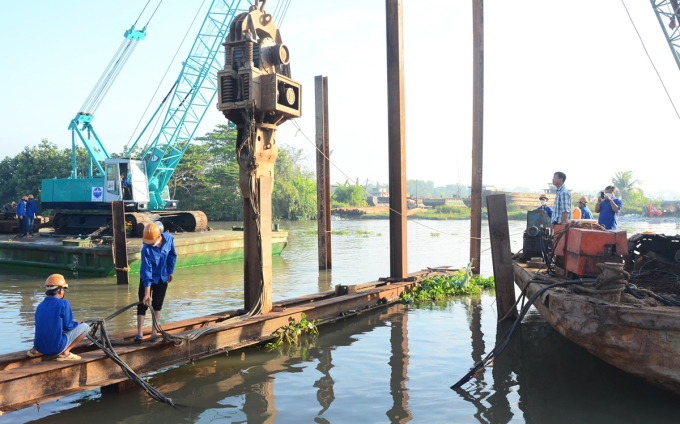 Công nhân thi công đập thép ngăn mặn trên kênh Nguyễn Tấn Thành. Ảnh: Hoàng Nam