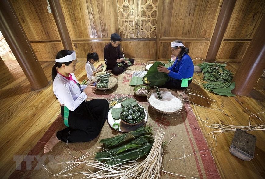 Gia đình quây quần gói bánh chưng, bánh ống trên nếp nhà sàn trong những ngày lễ, Tết là một nét đẹp văn hóa riêng có của người Mường tỉnh Hòa Bình. (Ảnh: Trọng Đạt/TTXVN)