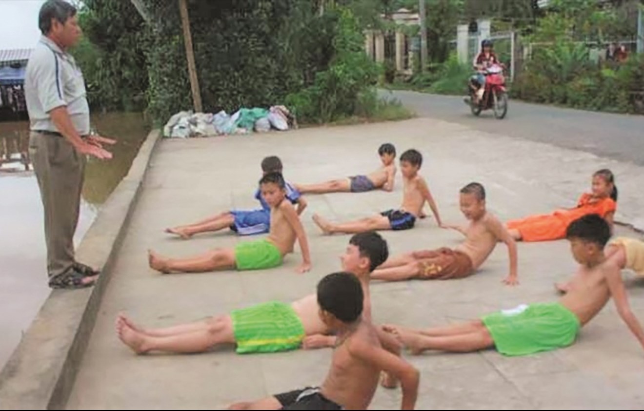 Thầy Lê Trung Sứng hướng dẫn các em khởi động trước khi tập bơi