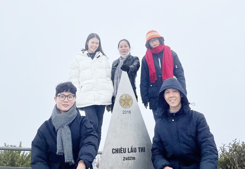 Chị Sạ Thị Yêm (ở giữa) cùng đoàn khách du lịch trải nghiệm đỉnh Chiêu Lầu Thi đầu năm 2022