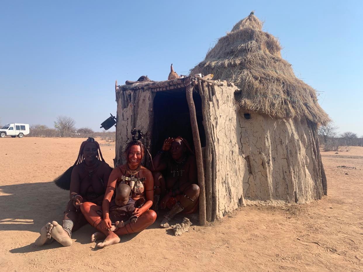 Một du khách Việt (người ngồi giữa) tham quan, trải nghiệm văn hóa cùa người Himba