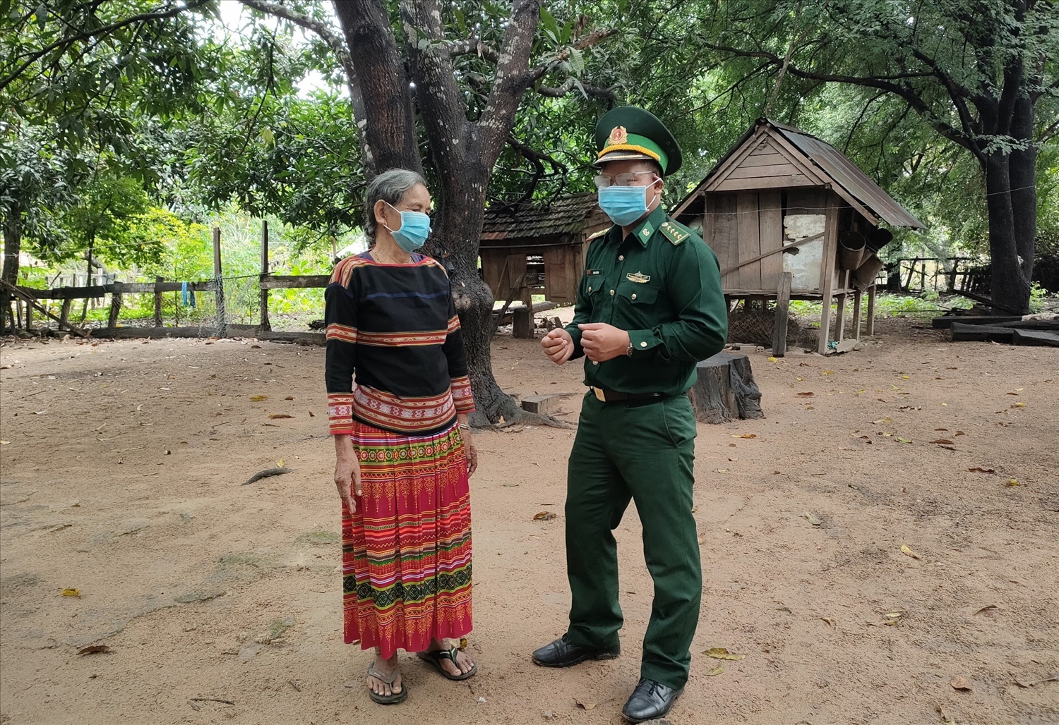 Đại úy Đinh ƠRing trao đổi với già làng Ksor H'Blâm về công tác xây dựng nông thôn mới