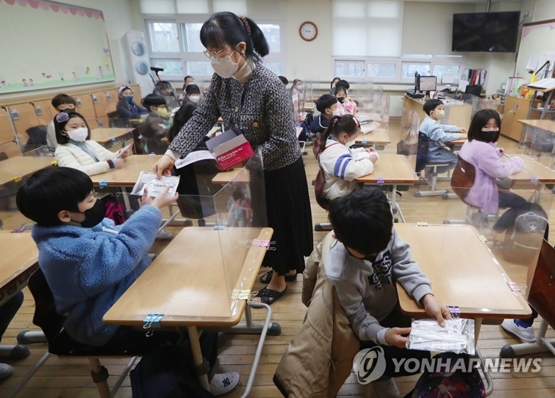 Giáo viên phát bộ dụng cụ tự kiểm tra COVID-19 cho học sinh tại trường tiểu học Bongmu ở Daegu, cách thủ đô Seoul của Hàn Quốc 300 km về phía Nam, ngày 2/3/2022. (Ảnh: Yonhap)