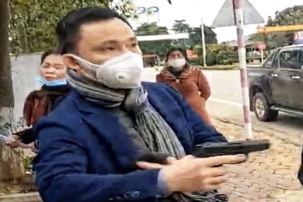 Ông Hồ Văn Nam rút súng uy hiếp (ảnh cắt từ clip)