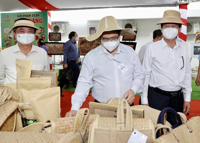 Thủ tướng Phạm Minh Chính tham quan một số gian hàng giới thiệu sản phẩm của vùng ĐBSCL được tổ chức bên lề Hội nghị. Ảnh TTXVN
