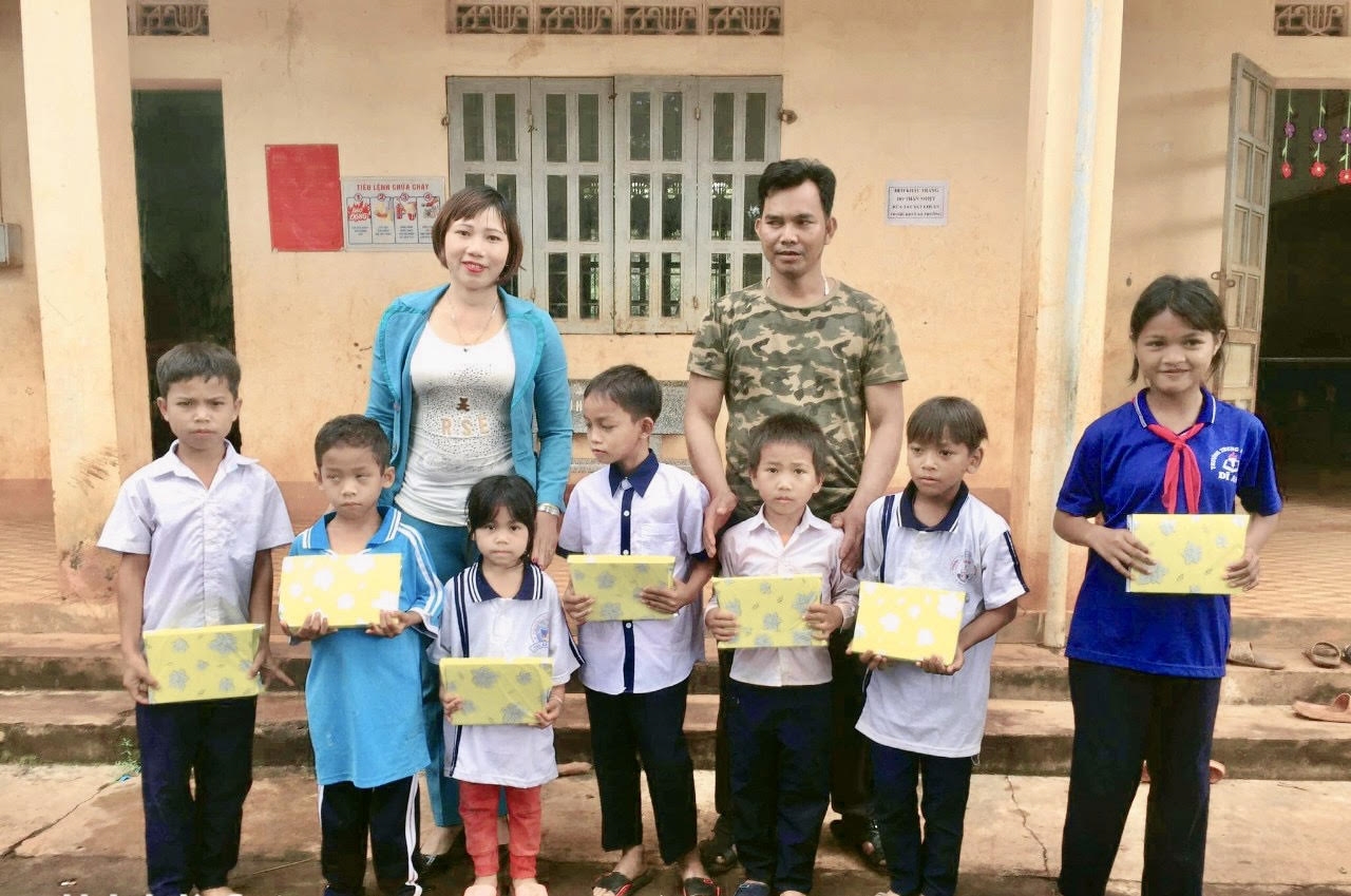 Chị Nông Thị Lành (áo xanh) đang trao những phần quà cho trẻ em đồng bào DTTS