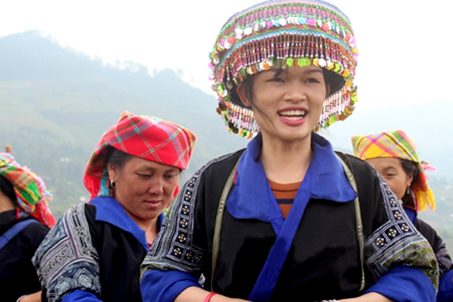 Chị Lý Thị Chơ (bên trái) ở bản Trống Tông, xã La Pán Tẩn giúp khách du lịch mặc trang phục truyền thống của người dân tộc Mông