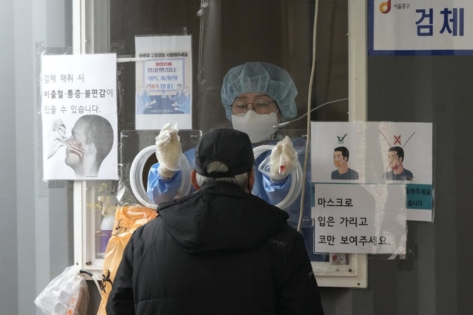 Nhân viên y tế lấy mẫu xét nghiệm cho người dân ở Hàn Quốc (Ảnh: AP)