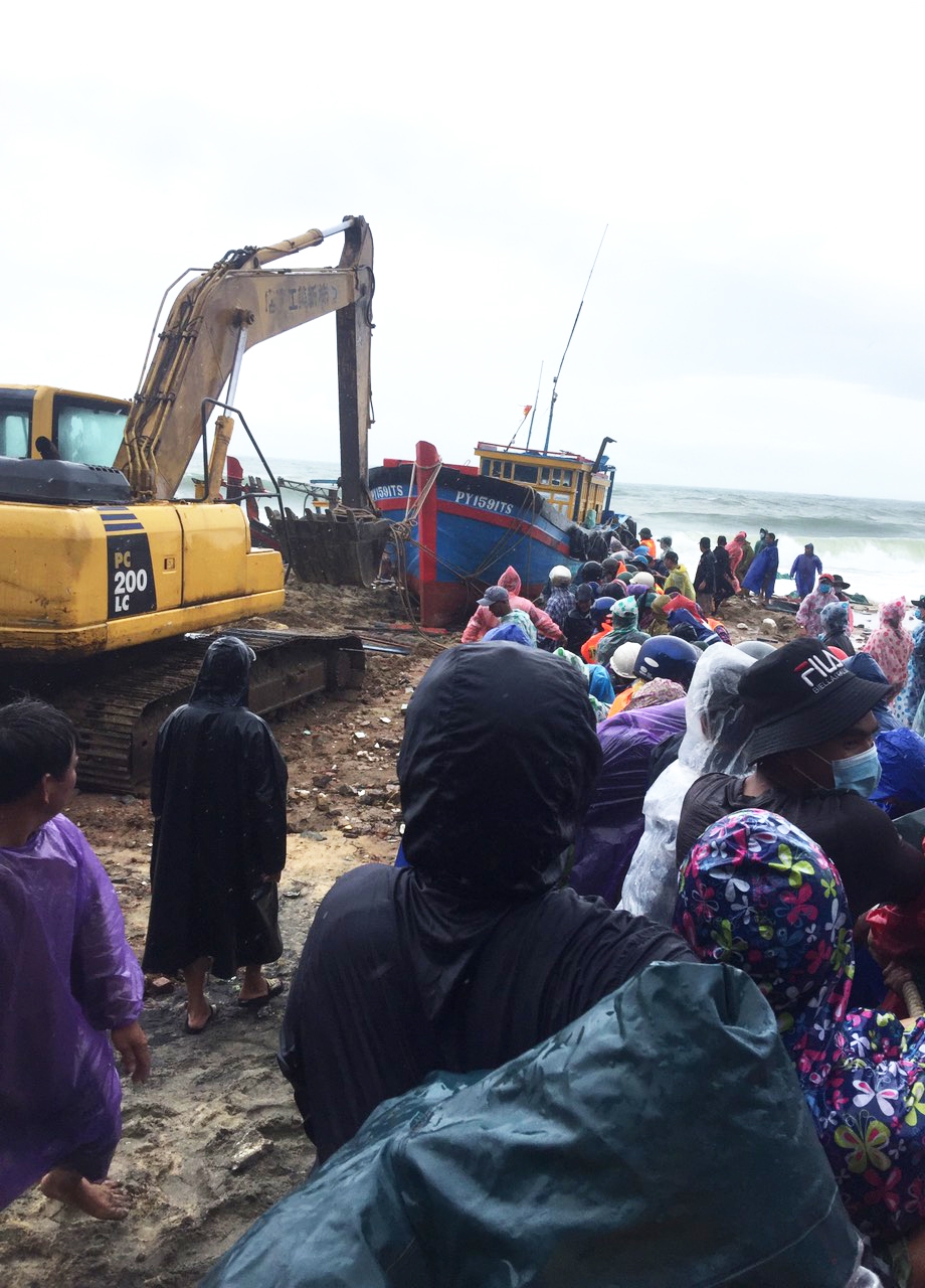Các lực lượng chức năng hỗ trợ người dân xã Nhơn Lý trục vớt tàu thuyền bị chìm