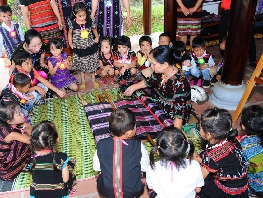 Các em học sinh mầm non ở A Ngo được các cô giáo giới thiệu về ý nghĩa của trang phục truyền thống của người Bru-Vân Kiều 