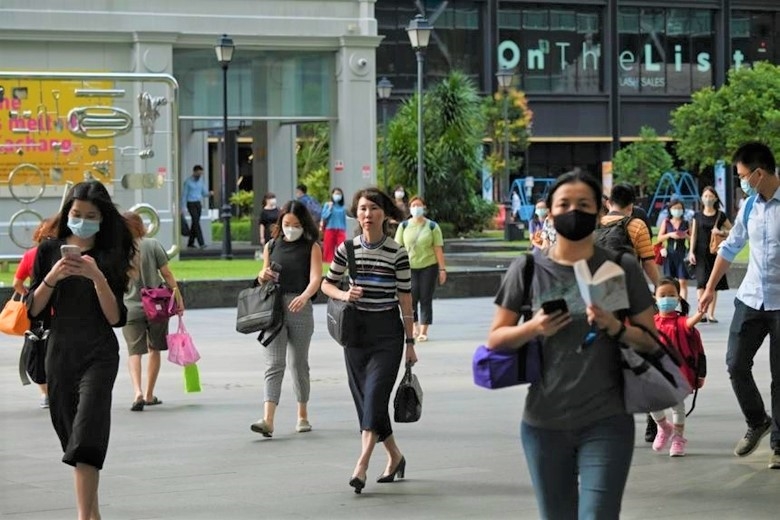Việc đeo khẩu trang ở ngoài trời không còn là bắt buộc ở Singapore (Ảnh: The Straits Times)
