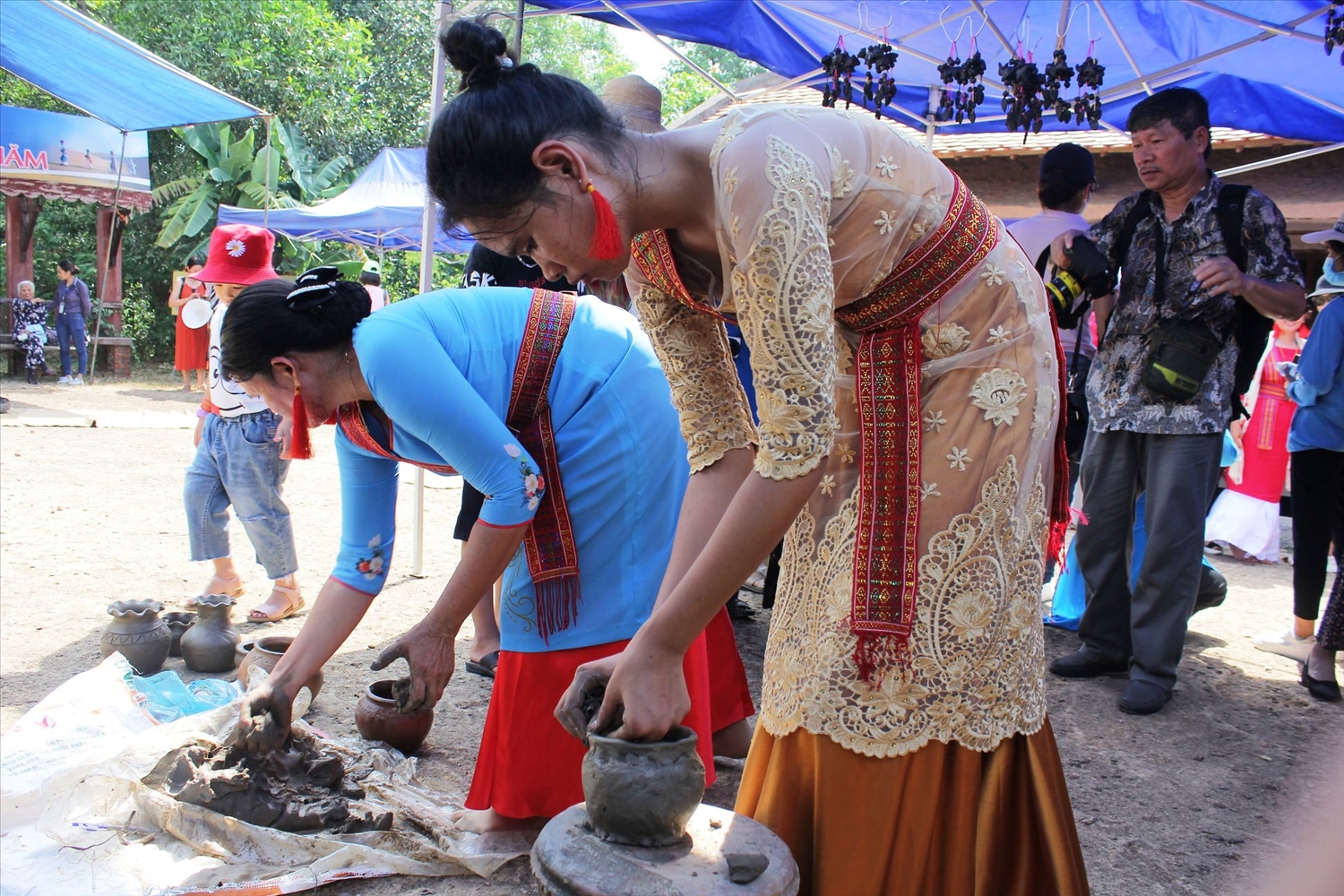Nghệ nhân Đàng Thị Hoa (áo xanh) đang truyền lại nghề gốm cho cô con gái út theo nghề làm gốm truyền thống của đồng bào Chăm.