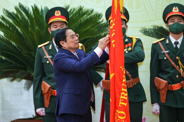 Thủ tướng Phạm Minh Chính gắn Huân chương Lao động hạng Nhất lên lá cờ truyền thống của tỉnh Ninh Thuận - Ảnh: VGP/Nhật Bắc