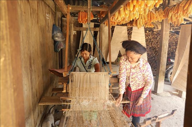 Truyền nghề dệt vải thổ cẩm là phong tục bắt buộc của người phụ nữ Mông trưởng thành đối với người trẻ (Ảnh TTXVN)
