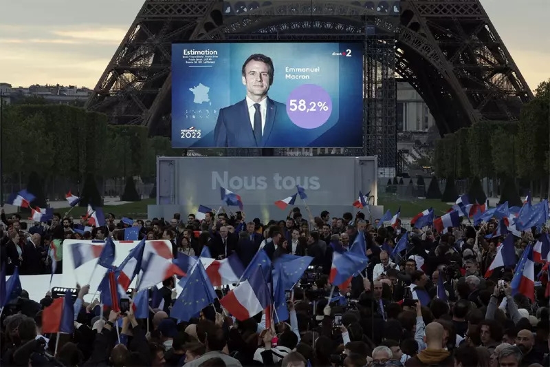 Những người ủng hộ ông Macron vẫy cờ ăn mừng việc đương kim tổng thống tái đắc cử. Ảnh: Reuters