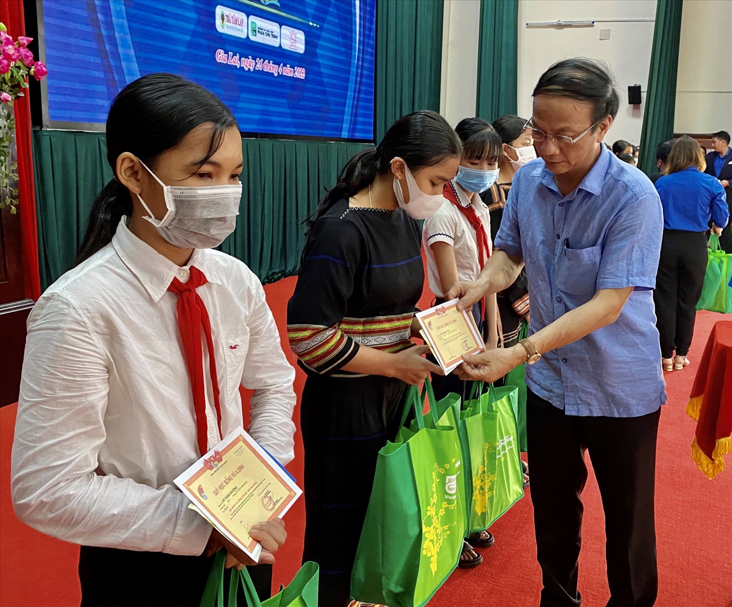 Ông Nguyễn Trân Châu, Phó Giám đốc Thường trực Quỹ học bỗng Vừ A Dính trao học bổng cho các em học sinh