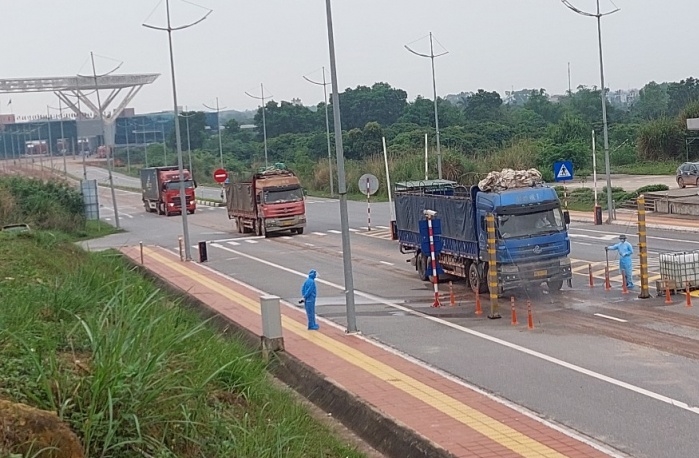 Các phương tiện vận tải phía Trung Quốc và Việt Nam chính thức lưu thông qua Cửa khẩu Bắc Luân II sau 2 tháng tạm dừng thông quan. (Ảnh: Hữu Việt)