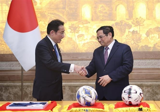  Thủ tướng Phạm Minh Chính và Thủ tướng Nhật Bản Kishida Fumio với tặng phẩm là 2 quả bóng có chữ ký của đội tuyển bóng đá 2 nước.