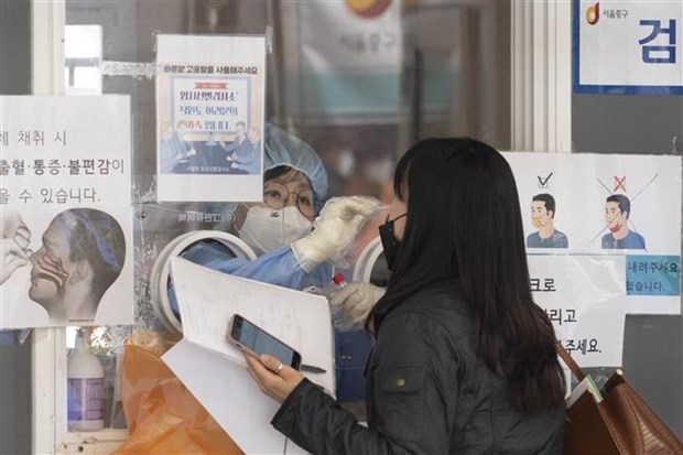 Nhân viên y tế lấy mẫu xét nghiệm COVID-19 cho người dân tại Seoul, Hàn Quốc. (Ảnh: THX/TTXVN)
