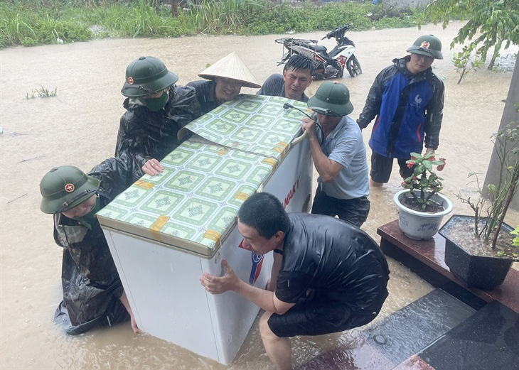 Cán bộ, chiến sĩ Đồn Biên phòng Quan Lạn, BĐBP Quảng Ninh giúp người dân khu phố 2, thị trấn Cái Rồng, huyện Vân Đồn di chuyển tài sản khỏi nơi ngập úng