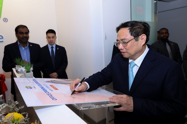 Thủ tướng ký lưu bút vào tấm biển kỷ niệm của trụ sở Văn phòng FPT Software - Ảnh VGP/Nhật Bắc
