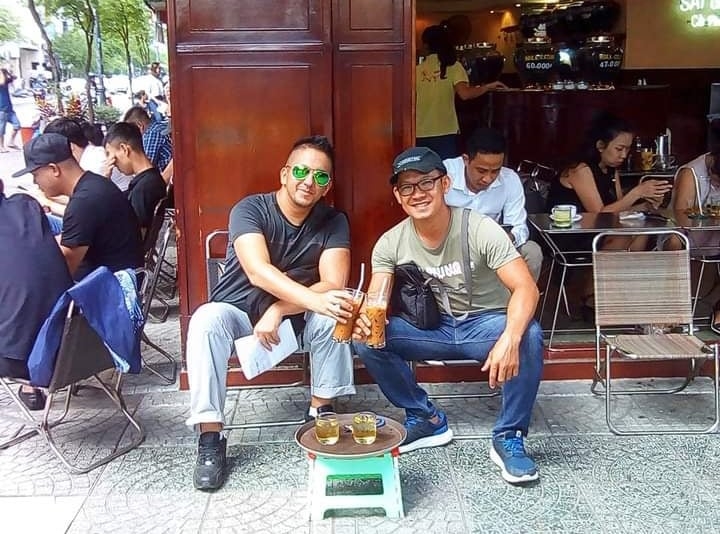 Du khách Châu Âu cùng hướng dẫn viên người Việt thưởng thức cà phê vỉa hè