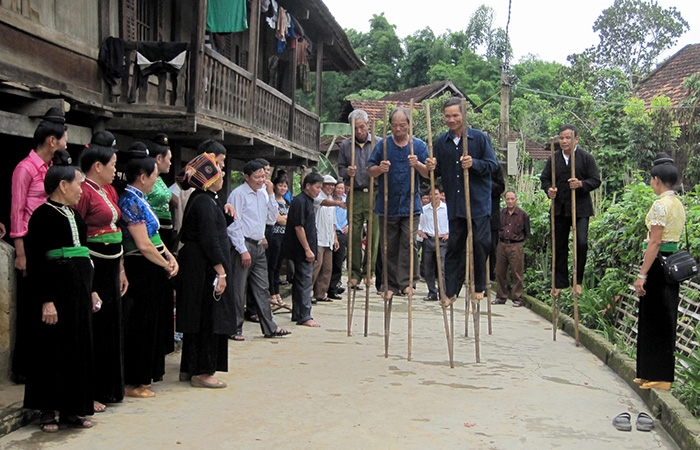 Đồng bào dân tộc Thái tham gia trò chơi thi đi cà kheo trong lễ Xên bản