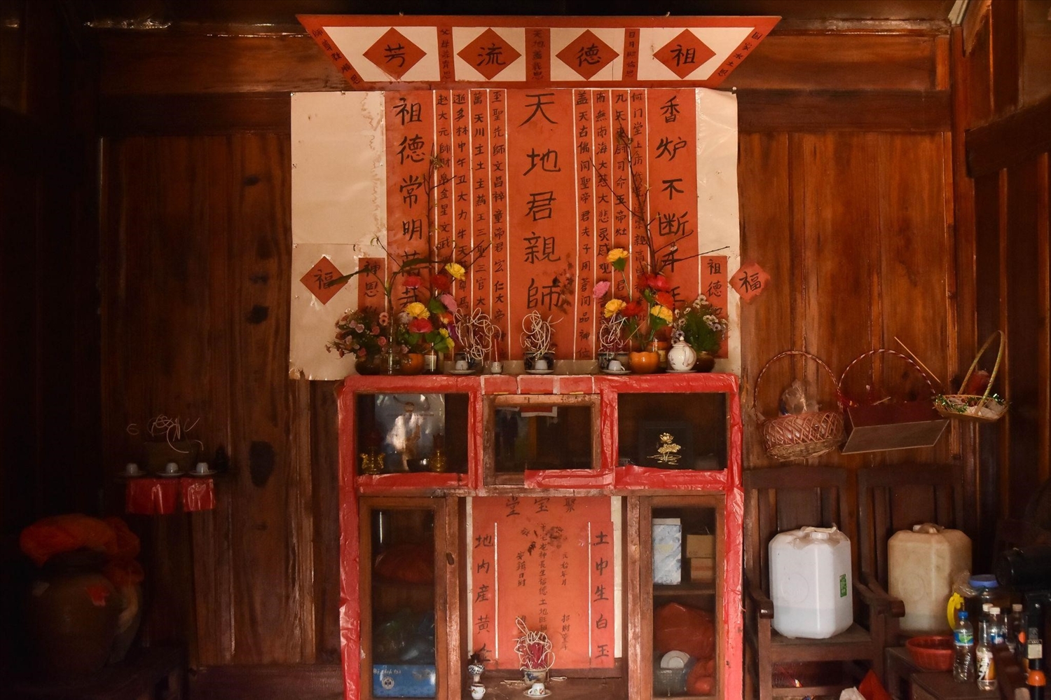 Khu vực bàn thờ được đặt ở vị trí trung tâm nhất trong nhà người Hoa, có màu đỏ là chủ đạo, bài trí thêm nhiều giấy hồng chữ Hán với nội dung cầu phúc, cầu lợi, cầu bình yên