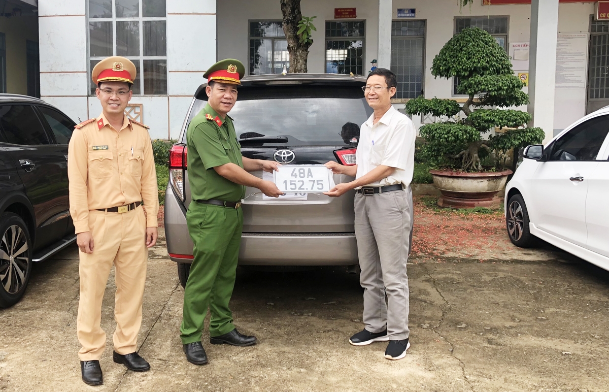 Lãnh đạo Công an huyện Đắk Mil trao biển số xe ô tô cho ông Nguyễn Văn Sơn