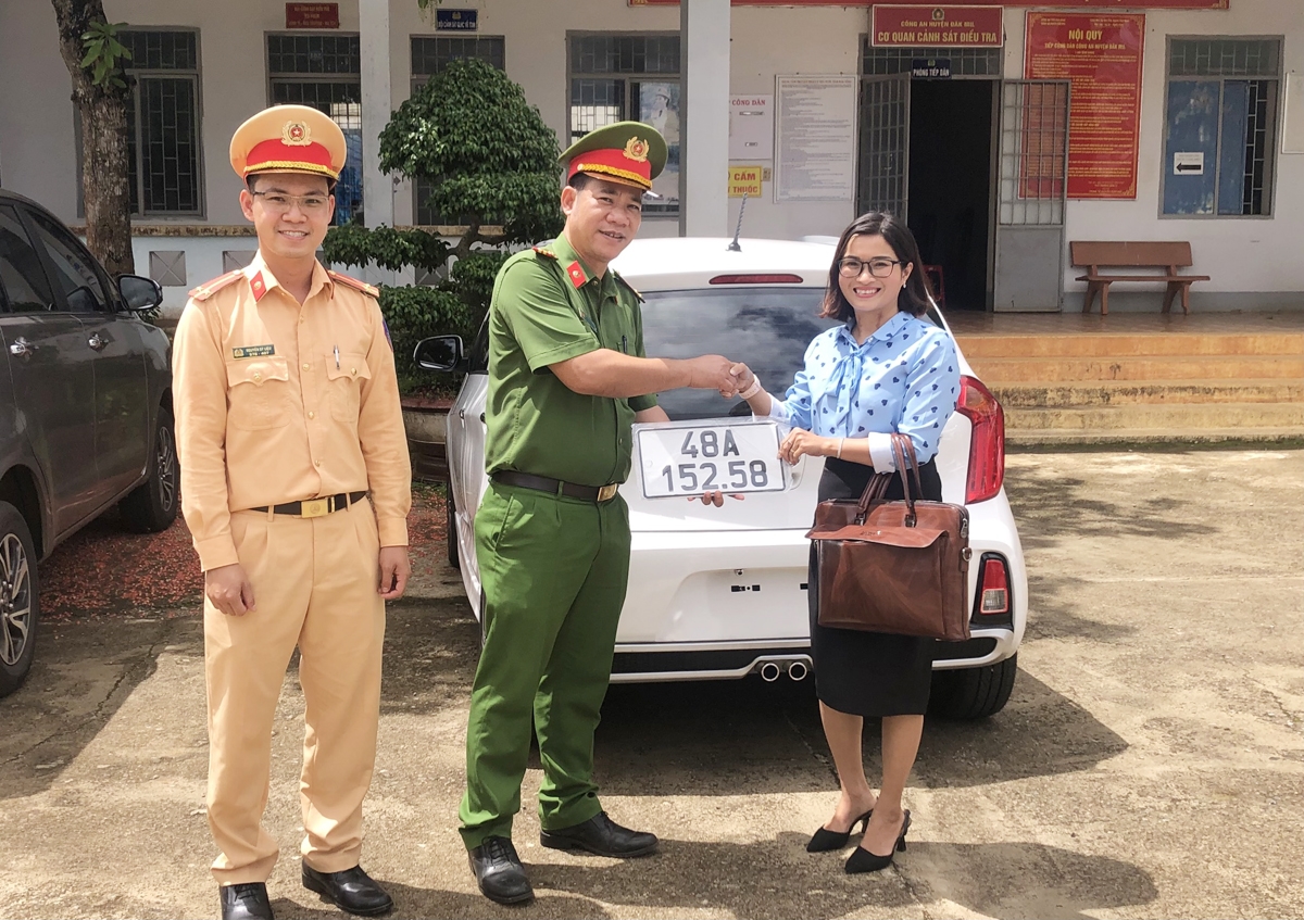 Lãnh đạo Công an huyện Đắk Mil trao biển số xe ô tô cho người dân trong ngày đầu tiên thực hiện cấp biển số tại Công an cơ sở
