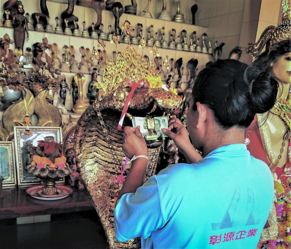 Người dân đến đền thờ rắn thường lễ bằng tiền hoặc viết mong ước của mình lên những mảnh giấy rồi đặt vào miệng bức tượng rắn