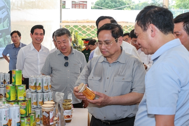 Thủ tướng nghe giới thiệu về một số sản phẩm đóng hộp xuất khẩu của Trung tâm Chế biến rau quả Doveco Sơn La - Ảnh: VGP/Nhật Bắc
